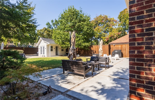 view of patio with an outdoor structure and an outdoor living space with a fire pit