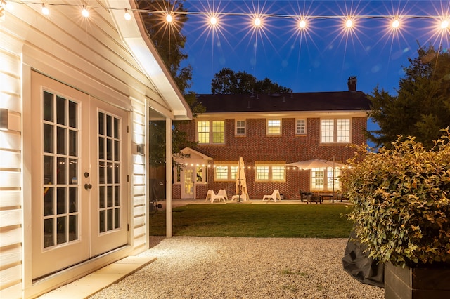 back of house featuring french doors, a patio, and a yard