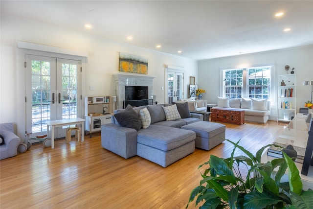 living room featuring ornamental molding, french doors, and light hardwood / wood-style flooring