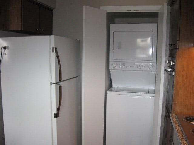 washroom featuring stacked washer / drying machine