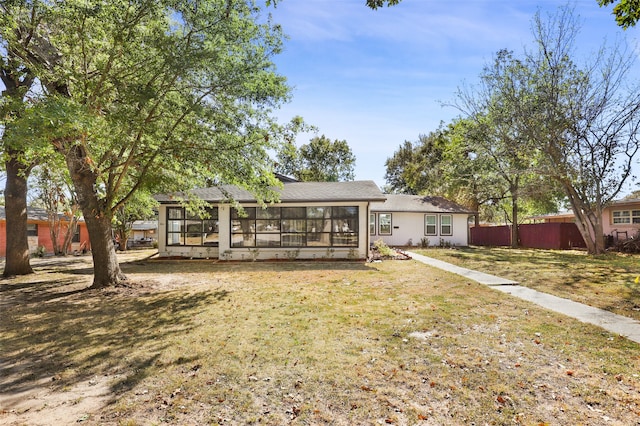 back of property featuring a yard and a sunroom