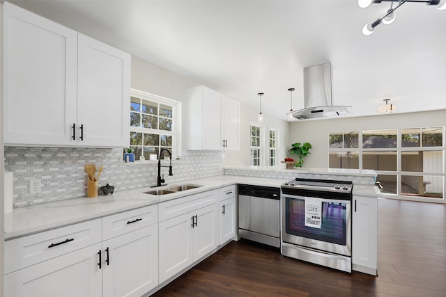 kitchen featuring kitchen peninsula, white cabinetry, island range hood, dark wood-type flooring, and stainless steel appliances