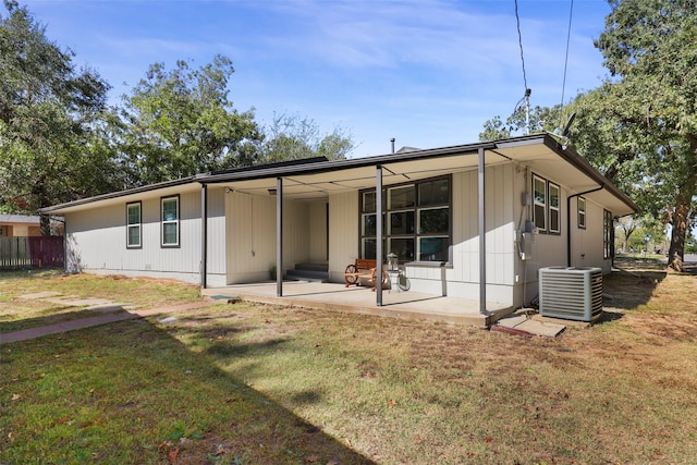 back of house with central air condition unit, a patio, and a lawn