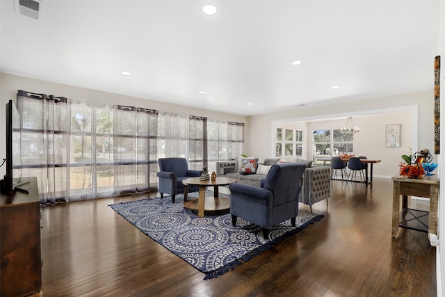 living room featuring an inviting chandelier, plenty of natural light, and dark hardwood / wood-style floors