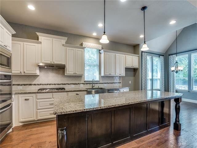 kitchen featuring a kitchen island, white cabinetry, a wealth of natural light, and hardwood / wood-style flooring