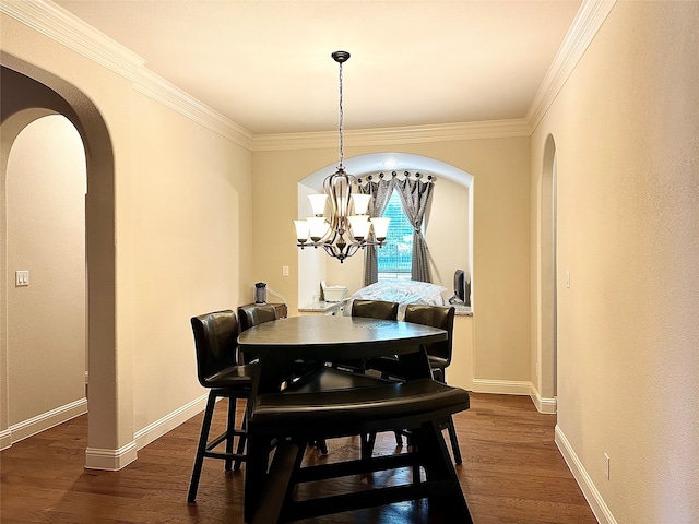 dining area with dark wood-type flooring, an inviting chandelier, and crown molding