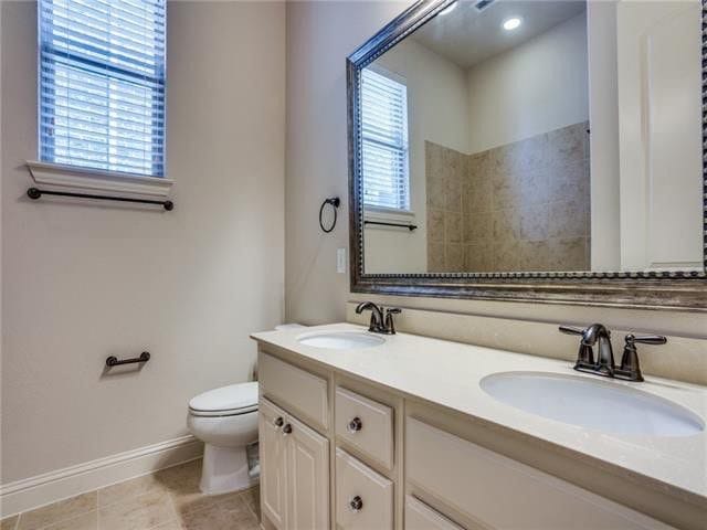 bathroom with tile patterned flooring, vanity, and toilet