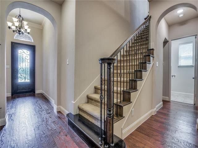 entrance foyer with a notable chandelier, dark hardwood / wood-style flooring, and ornamental molding