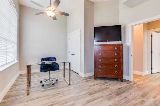 home office with light hardwood / wood-style flooring and ceiling fan