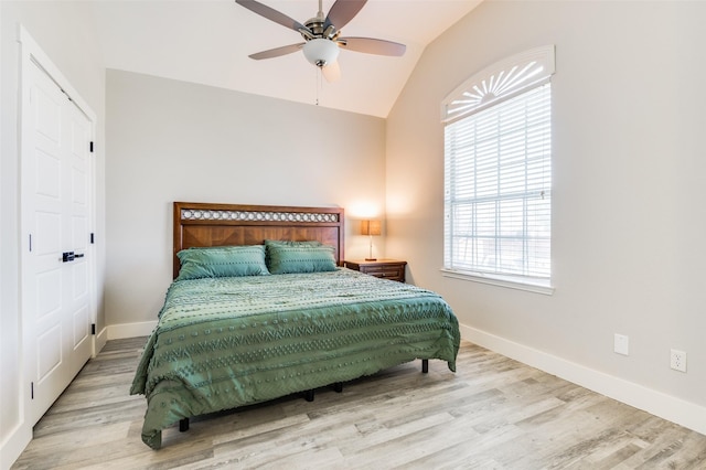 bedroom with multiple windows, ceiling fan, light hardwood / wood-style floors, and vaulted ceiling