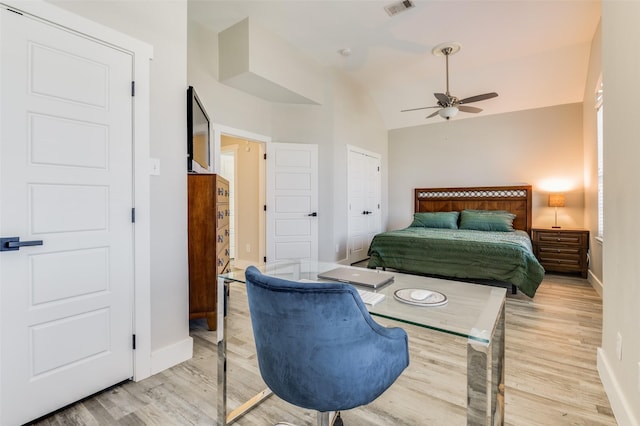 bedroom featuring light wood-type flooring, vaulted ceiling, and ceiling fan