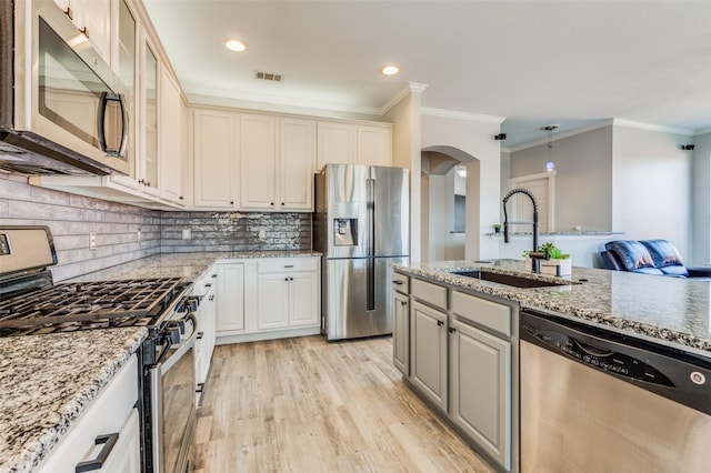 kitchen with stainless steel appliances, hanging light fixtures, ornamental molding, and sink