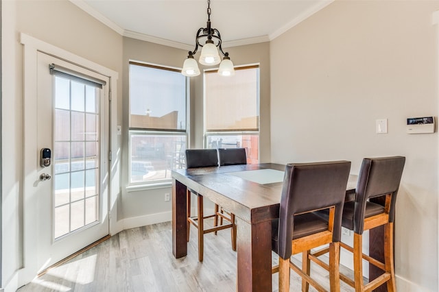 dining room featuring light wood-type flooring and crown molding