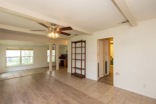 tiled empty room featuring ceiling fan and beam ceiling