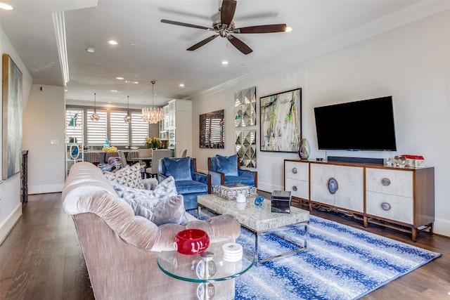 living room with ceiling fan with notable chandelier, ornamental molding, and dark hardwood / wood-style floors