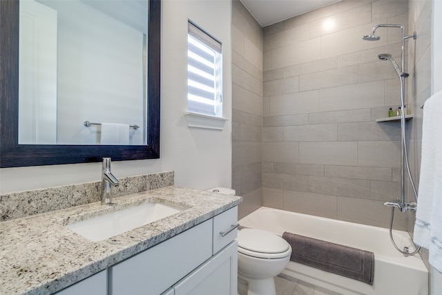 full bathroom featuring vanity, tiled shower / bath combo, and toilet