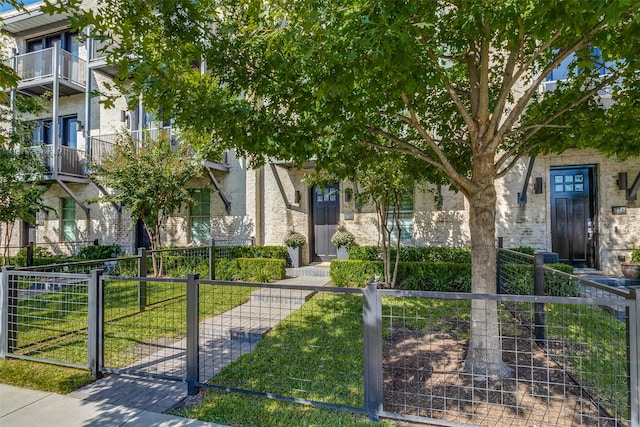 view of front of house with a front lawn and a balcony