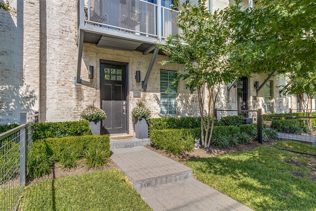 doorway to property with a lawn and a balcony