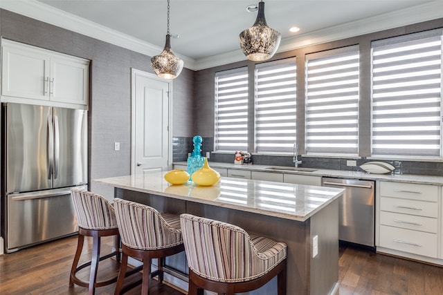 kitchen with white cabinets, stainless steel appliances, sink, and a kitchen island