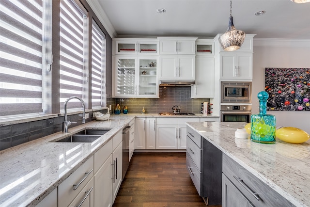 kitchen featuring tasteful backsplash, appliances with stainless steel finishes, pendant lighting, white cabinets, and light stone counters