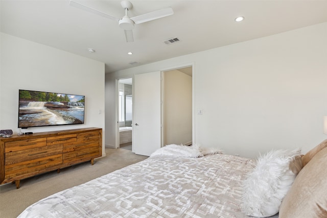 carpeted bedroom with ceiling fan and ensuite bath