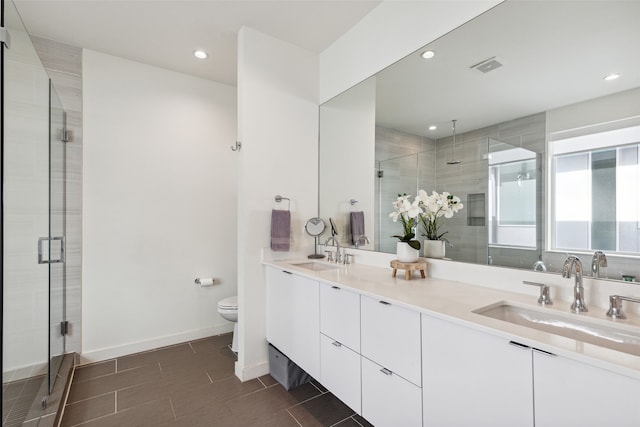 bathroom with walk in shower, vanity, and toilet