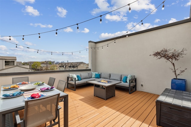 wooden terrace featuring an outdoor living space with a fire pit