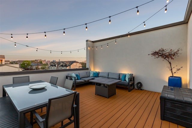 deck at dusk featuring an outdoor living space with a fire pit