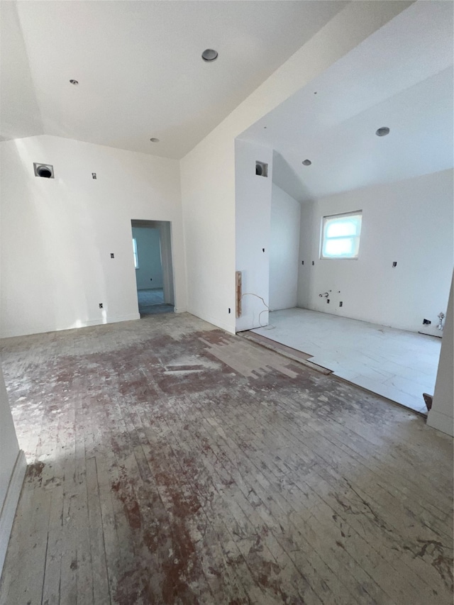 unfurnished living room featuring vaulted ceiling and hardwood / wood-style floors