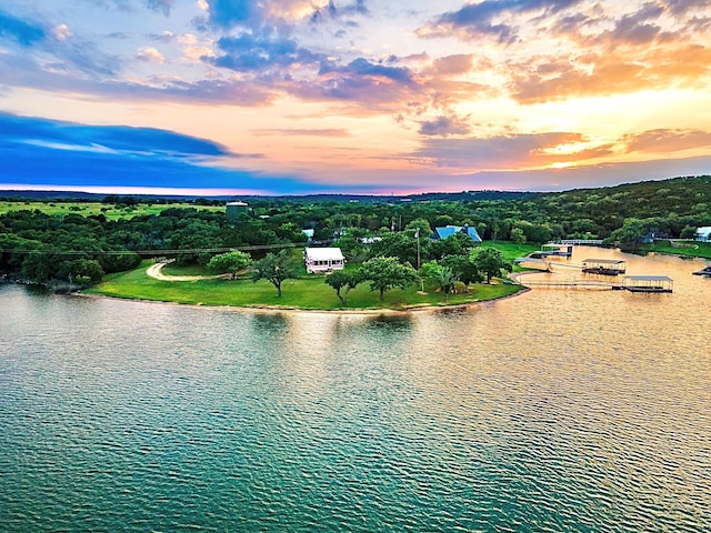 aerial view at dusk featuring a water view