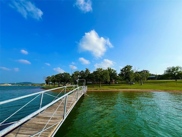 dock area with a yard and a water view