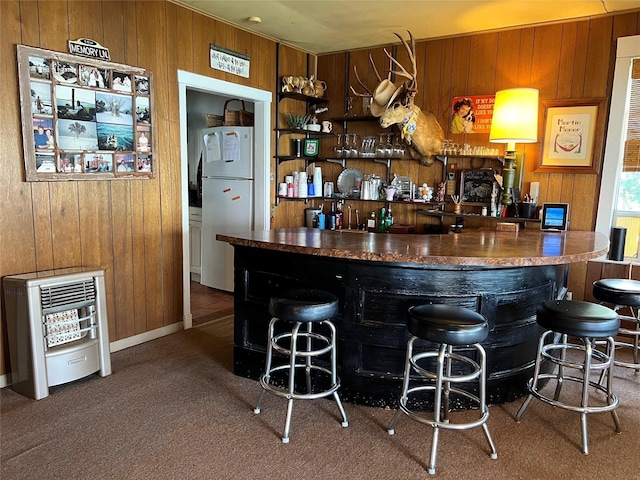bar with freestanding refrigerator, wood walls, and a dry bar
