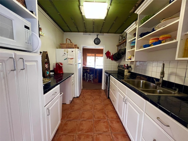 kitchen featuring white appliances, white cabinetry, tile counters, and a sink