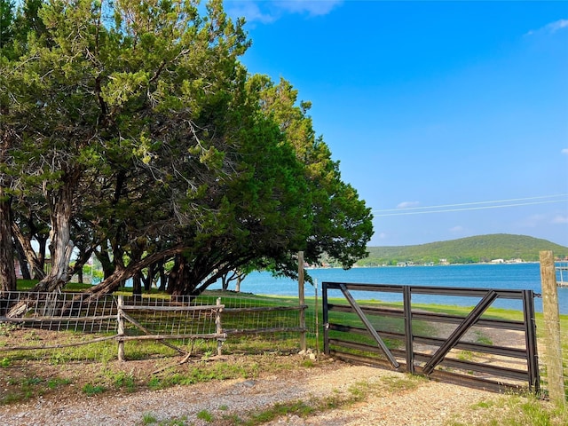 view of gate with a water and mountain view