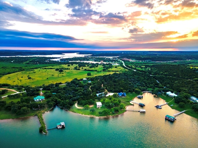 aerial view at dusk featuring a water view