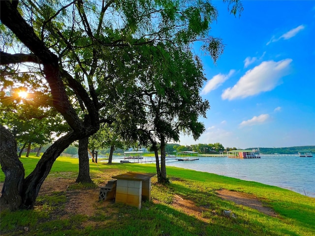 view of property's community featuring a lawn and a water view