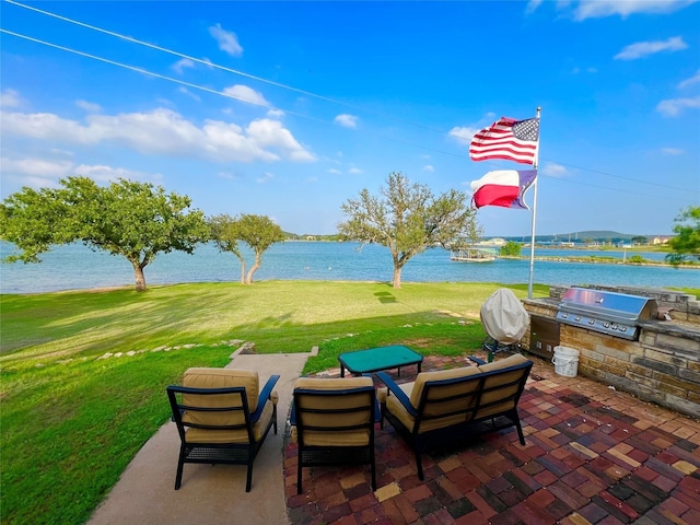 view of patio / terrace with outdoor dining area, exterior kitchen, a water view, and a grill