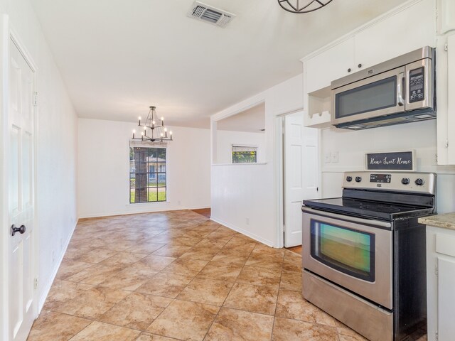 kitchen with hanging light fixtures, light tile patterned floors, a chandelier, white cabinetry, and appliances with stainless steel finishes