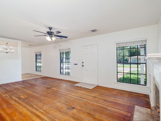 entrance foyer with hardwood / wood-style flooring, ceiling fan with notable chandelier, and a healthy amount of sunlight