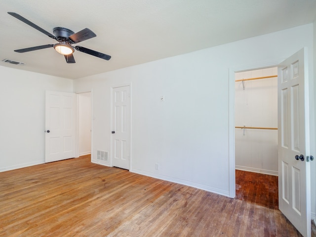 unfurnished bedroom with ceiling fan and hardwood / wood-style floors