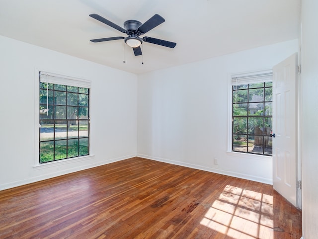 empty room featuring plenty of natural light, hardwood / wood-style flooring, and ceiling fan