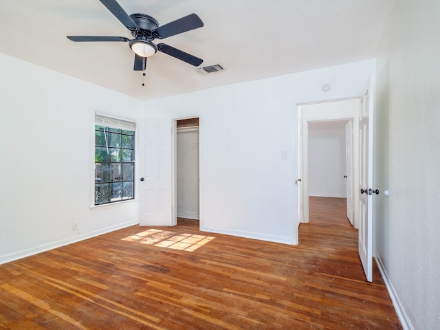 unfurnished bedroom with a closet, dark hardwood / wood-style flooring, and ceiling fan