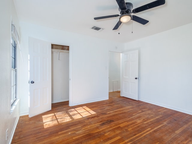 unfurnished bedroom with a closet, hardwood / wood-style flooring, and ceiling fan