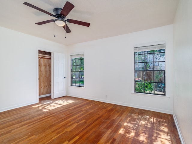 unfurnished room featuring ceiling fan, plenty of natural light, and hardwood / wood-style floors