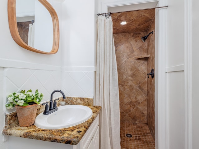 bathroom with tile walls, vanity, and curtained shower