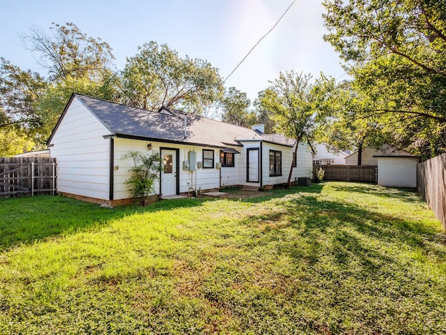 back of house featuring a lawn and central air condition unit