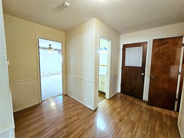 foyer featuring hardwood / wood-style floors, a textured ceiling, and ceiling fan