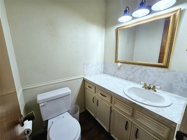 bathroom with tile walls, vanity, and toilet