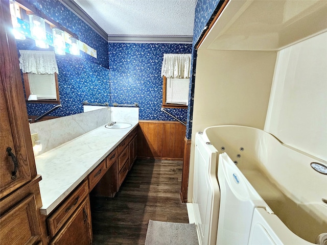 bathroom featuring a tub to relax in, wooden walls, hardwood / wood-style flooring, vanity, and a textured ceiling