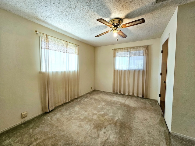 spare room with ceiling fan, light carpet, a textured ceiling, and a healthy amount of sunlight